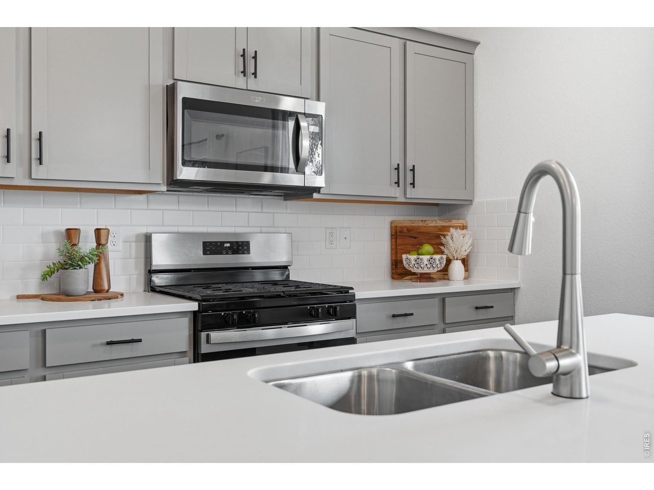 Property Photo 7 Quality finishes throughout, including quartz counters, stainless appliances, and a deep double-basin sink.