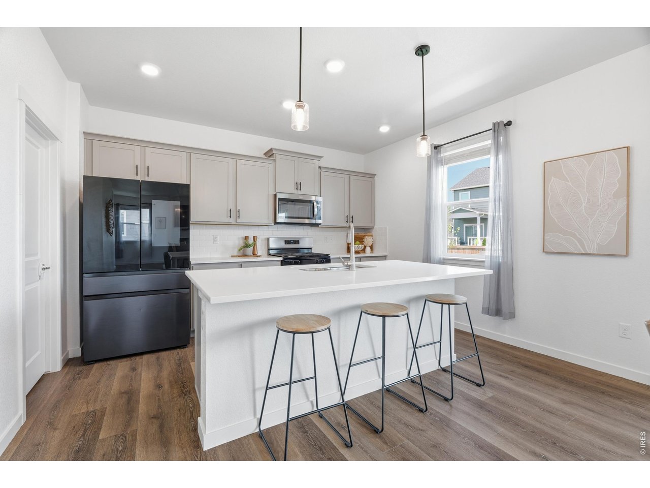 Property Photo 6 Spacious eat-in kitchen with quartz counters, subway-tile backsplash, and sleek black stainless appliances.