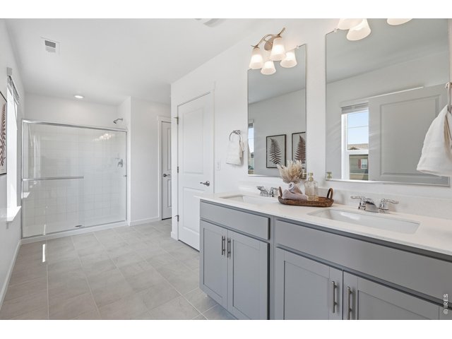 Property Photo 19 Spa-like primary bath with dual gray vanities, quartz counters, and a large walk-in shower.