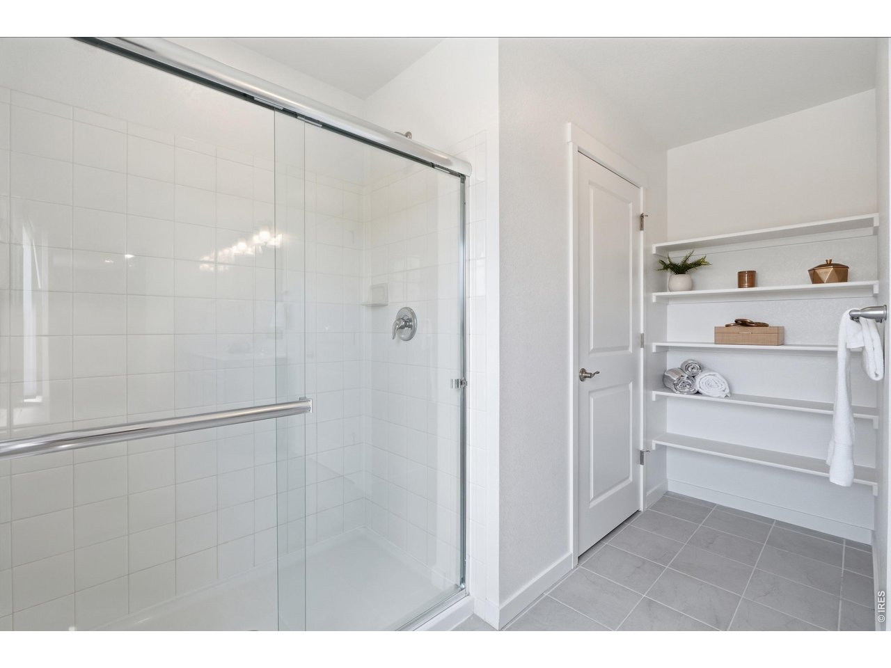 Property Photo 20 Oversized glass walk-in shower paired with built-in linen shelving & extra closet for smart, everyday storage.