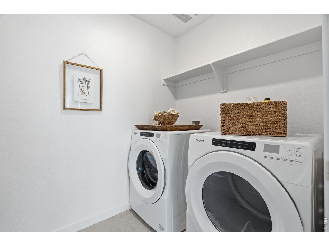 Property Photo 25 Dedicated upstairs laundry with full-size Whirlpool washer and dryer plus overhead shelving, included with the home.