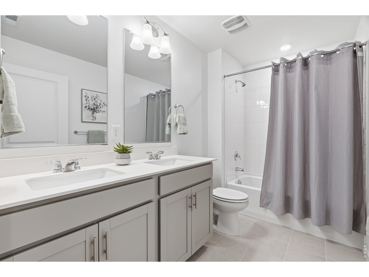 Property Photo 32 Shared upstairs full bath with dual quartz-topped vanities and a tub/shower combo.