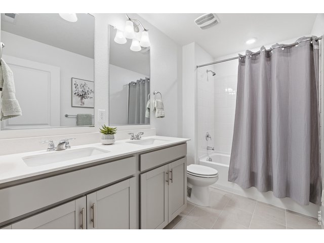 Property Photo 32 Shared upstairs full bath with dual quartz-topped vanities and a tub/shower combo.
