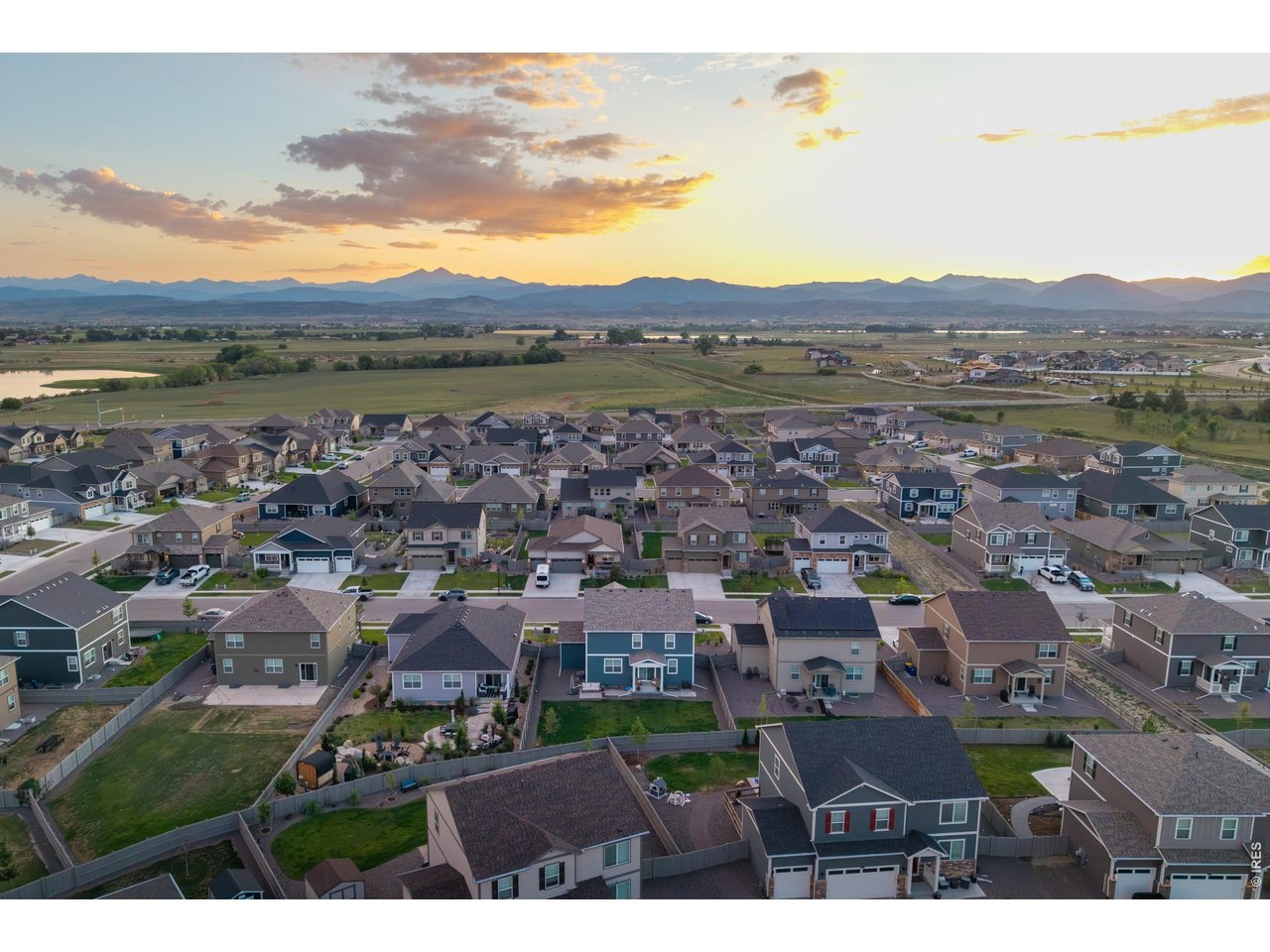 Property Photo 2 Sweeping aerial showcasing the neighborhood's front-range mountain backdrop and nearby reservoir.