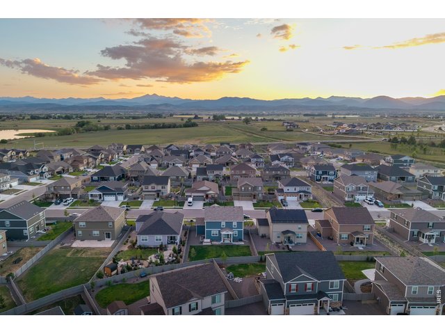 Property Photo 2 Sweeping aerial showcasing the neighborhood's front-range mountain backdrop and nearby reservoir.