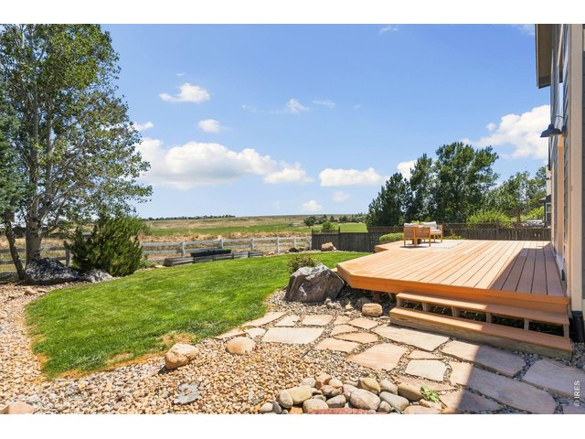 Property Photo 28 Backyard with a large deck backing to small acreage