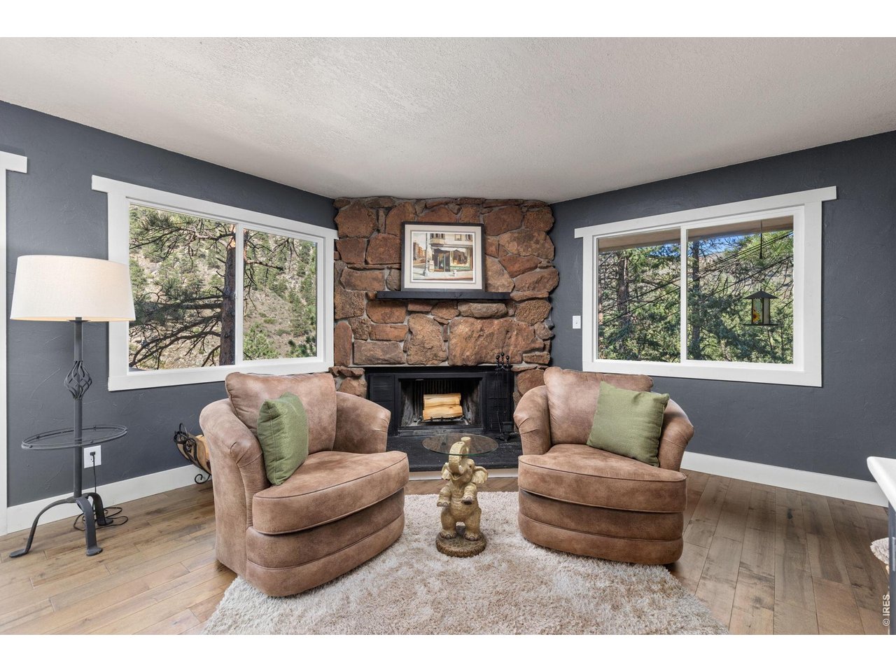 Property Photo 17 Wood-burning fireplace surrounded by natural moss rock adds classic mountain character.