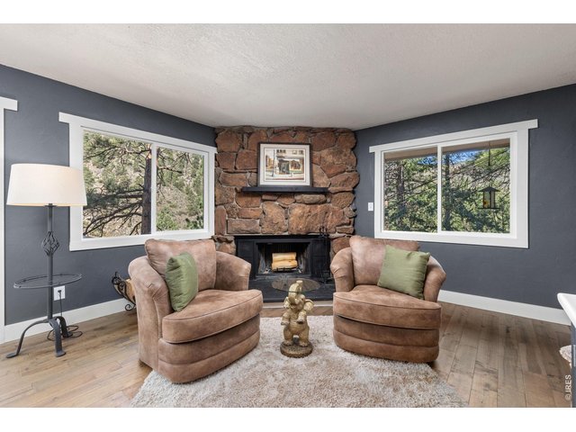Property Photo 17 Wood-burning fireplace surrounded by natural moss rock adds classic mountain character.