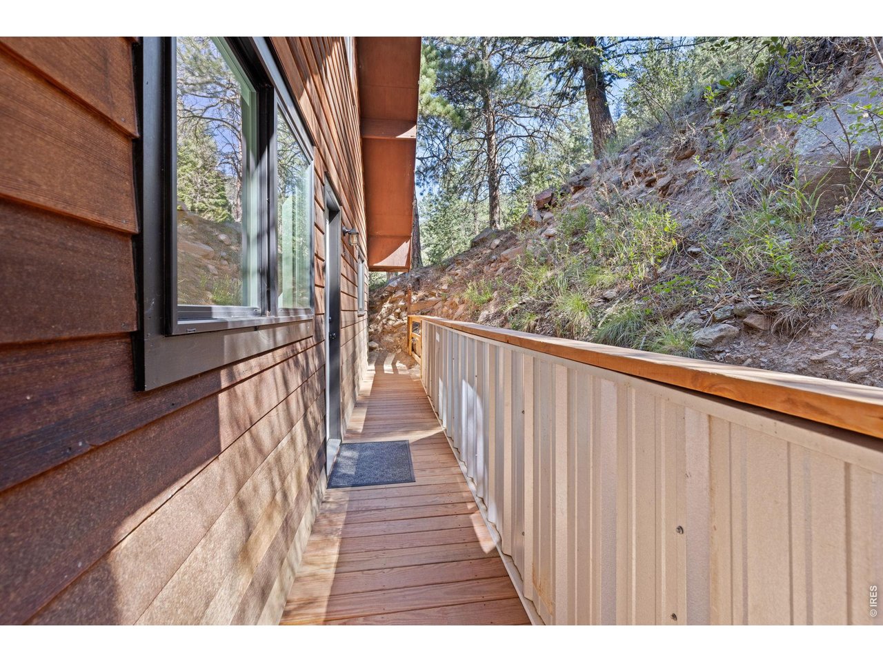 Property Photo 35 A wood walkway wraps along the back of the home, connecting to an additional deck area tucked into the natural surroundings.