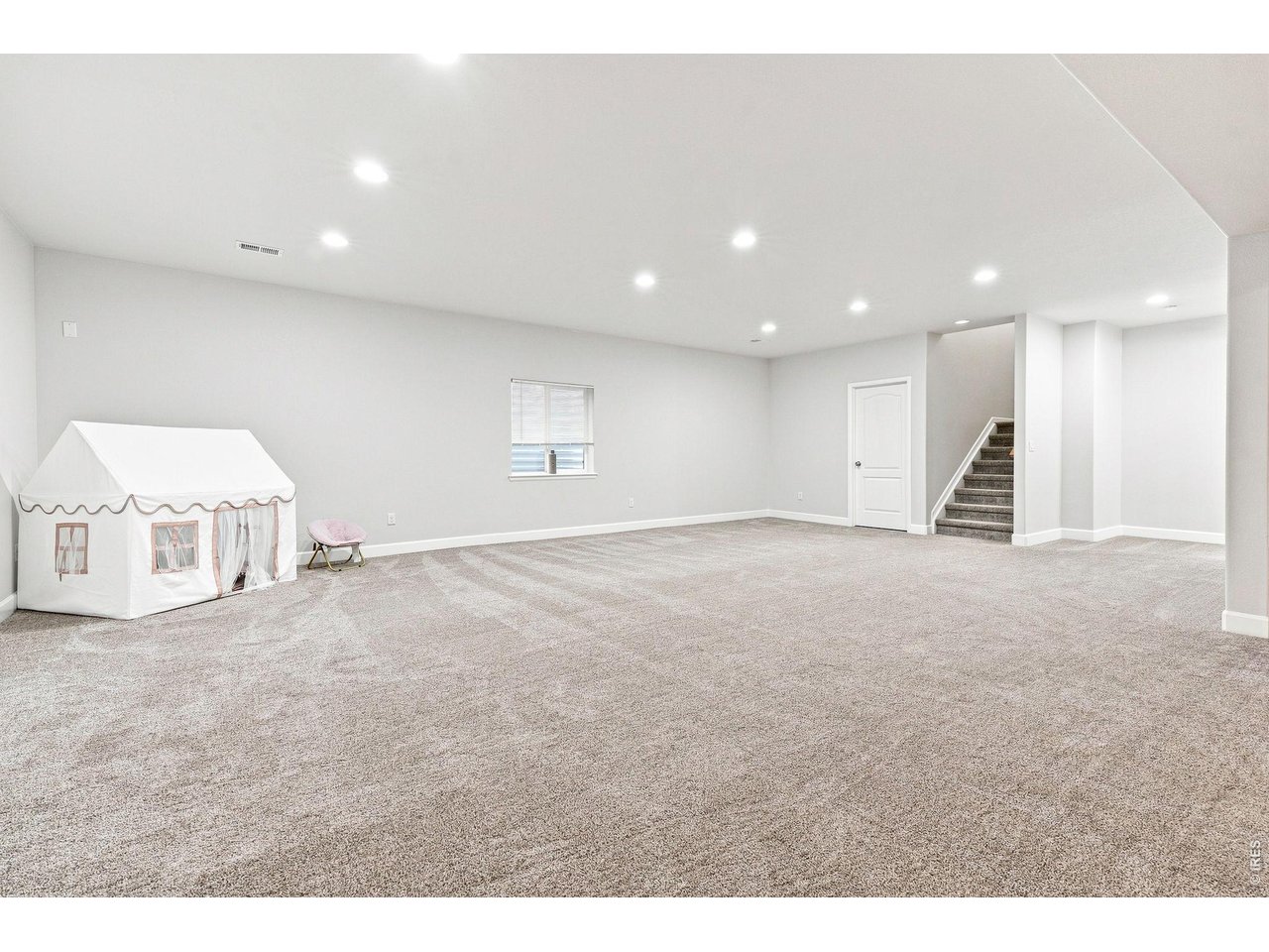 Property Photo 29 Finished basement with a huge recreation room, dedicated theater room complete with a 139-inch screen and surround sound, plus a private fourth bedroom with a walk-in closet and three-quarter bath