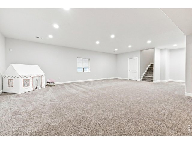 Property Photo 29 Finished basement with a huge recreation room, dedicated theater room complete with a 139-inch screen and surround sound, plus a private fourth bedroom with a walk-in closet and three-quarter bath
