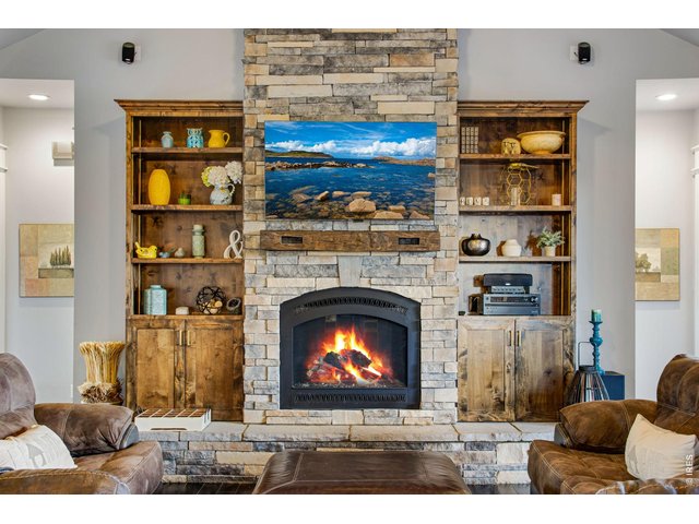 Property Photo 15 custom cabinetry and shelving bookending a stone gas fireplace.