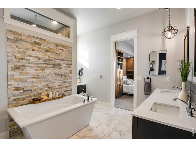 Property Photo 28 Spa like primary bathroom with stone accents and brand new heated tile floors.
