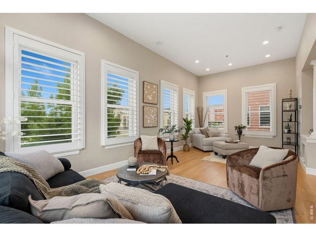 Property Photo 5 Large, sunny living room with high ceilings and abundant east morning light.