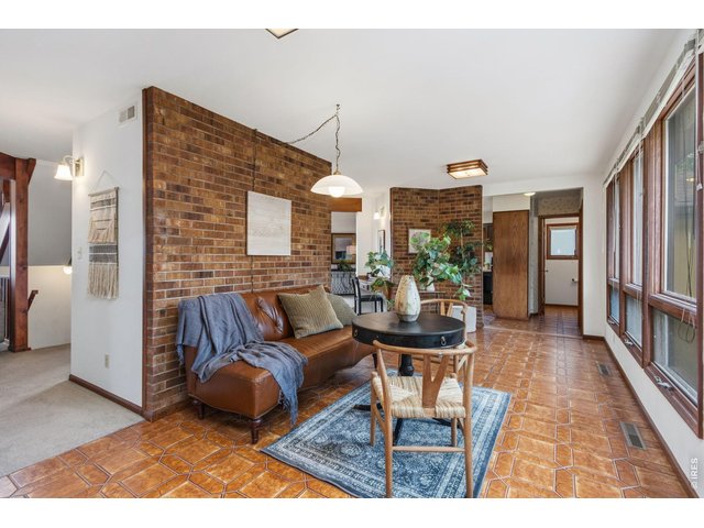 Property Photo 5 Inviting solar room with abundant natural light and serene views of the front yard and patio.