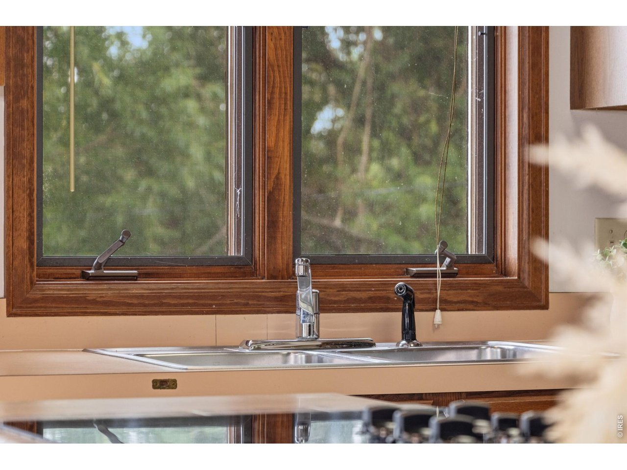 Property Photo 19 Kitchen window overlooking the mature trees and lush landscape surrounding the property.