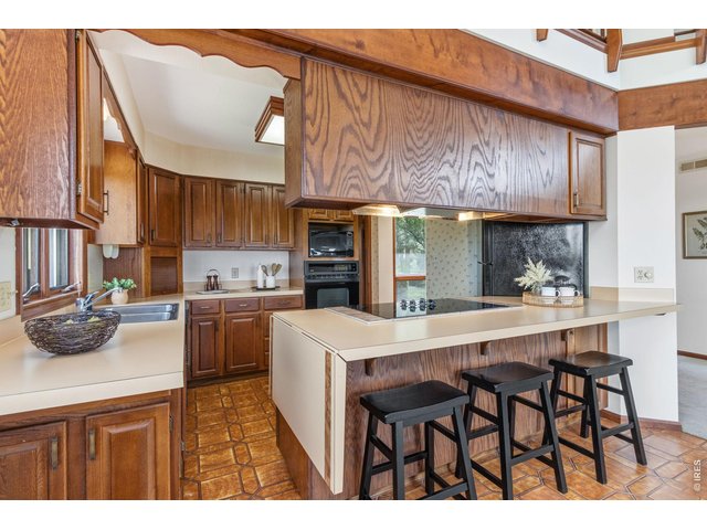 Property Photo 18 Kitchen boasts an eat-in bar, solid wood cabinets and lots of storage.