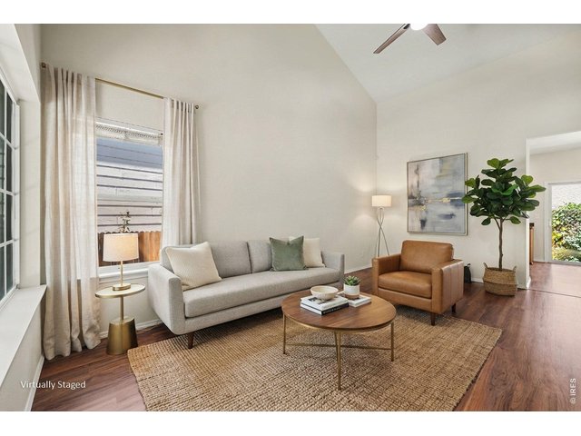 Property Photo 2 Staged living room with cathedral ceiling and ceiling fan