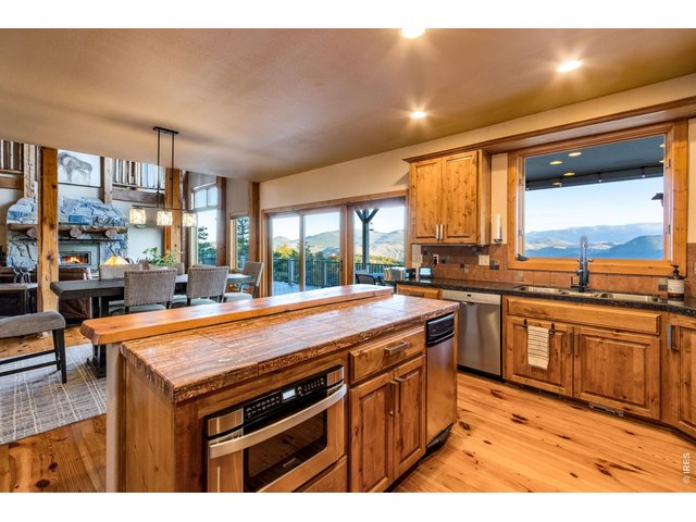 Property Photo 22 granite tile countertops, knotty alder cabinets, crown molding, hardware, Lazy Susan, undermount lighting, stainless steel appliances, double ovens, 6-burner gas range, hood system, pot rack and trash compactor