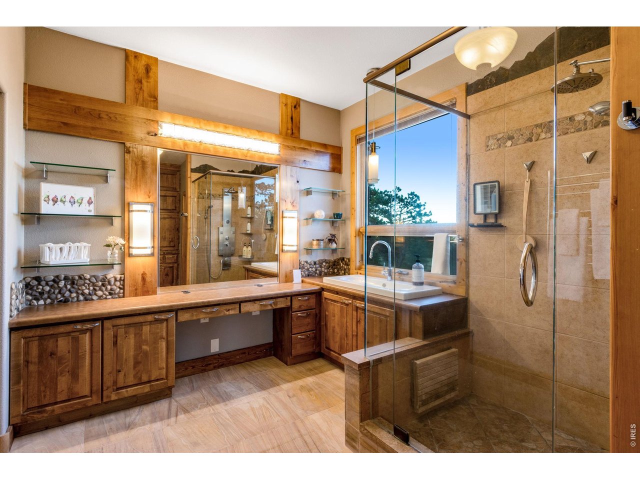 Property Photo 29 walk-in closet, luxury private bath featuring built-in cabinetry, sandstone tile flooring with radiant in-floor heat, heated towel rack, shower with overhead + 6 body jets and a wand, 2 lifted vanities, door to throne, glass shelving