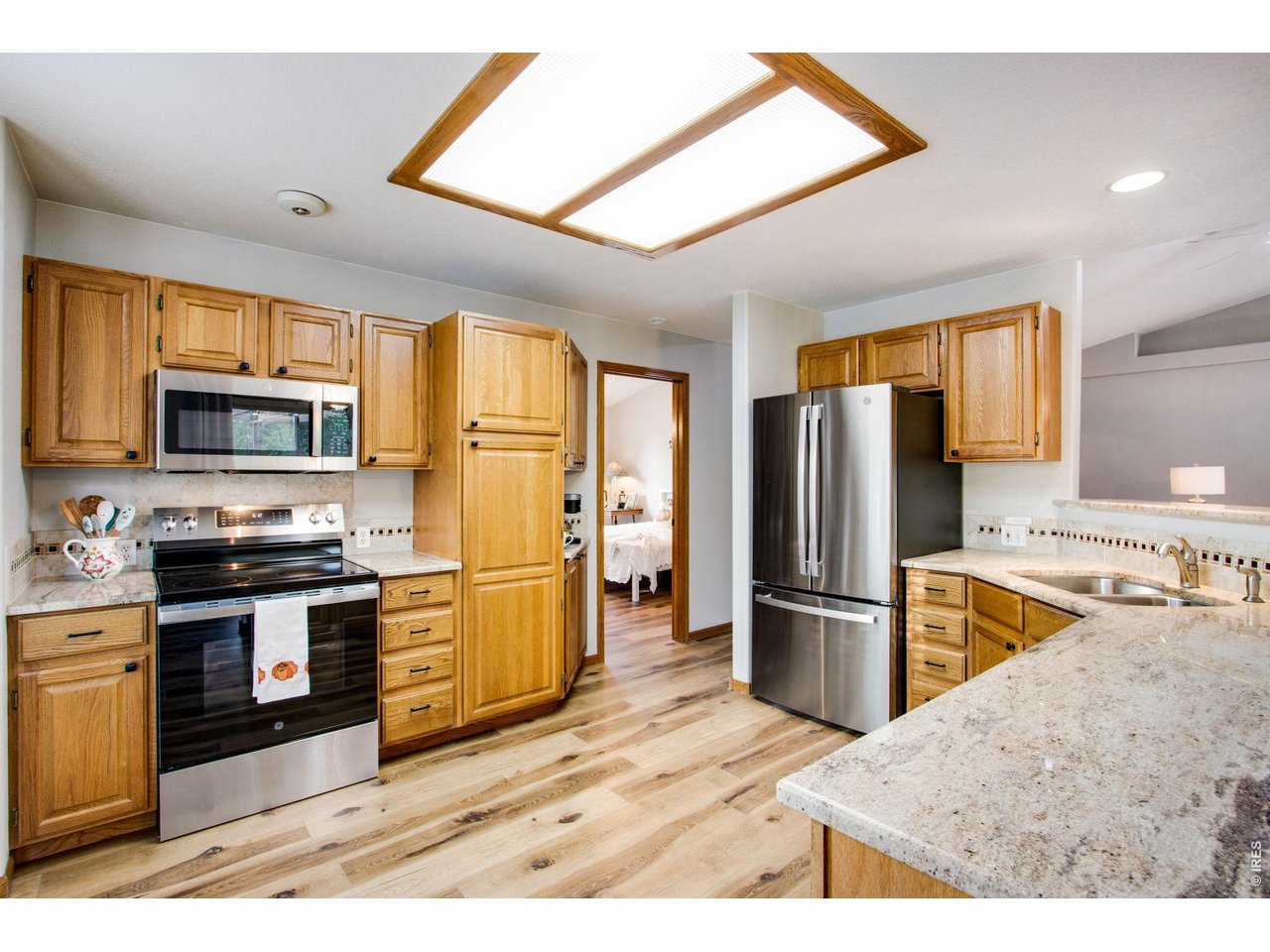 Property Photo 12 Spacious and open kitchen featuring granite slab countertops, tile backsplash, all new stainless-steel appliances, plenty of cabinets with hardware and roll-out drawers