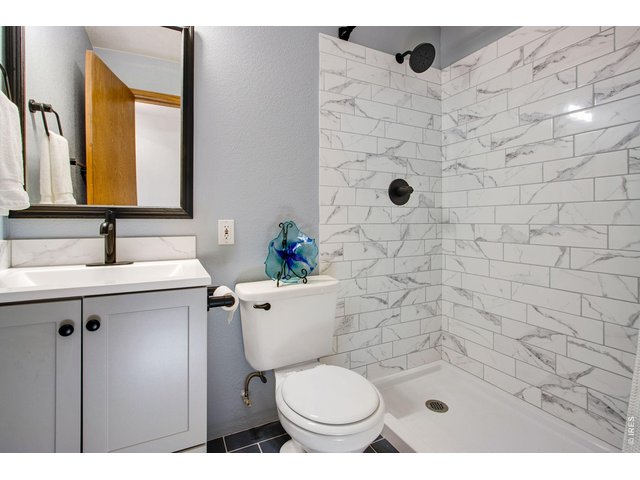 Property Photo 33 bath is fully remodeled and features tile flooring and backsplash, lifted vanity, quartz countertop, and an upgraded mirror and light fixture