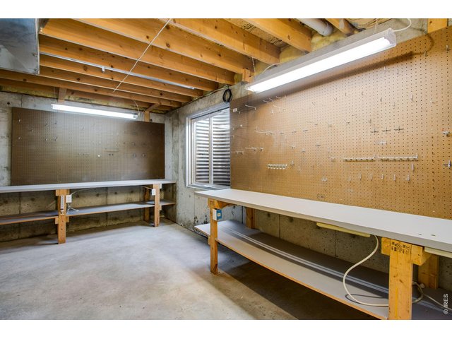 Property Photo 34 Large unfinished portion is perfect for your crafts or a shop and includes 2 work benches, peg board, added electrical outlets, window and shelving
