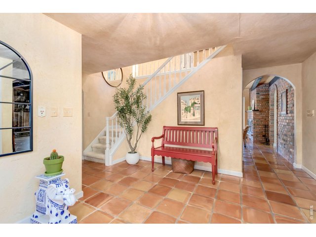 Property Photo 19 Grand foyer featuring authentic Spanish tile flooring and beautiful architectural details.