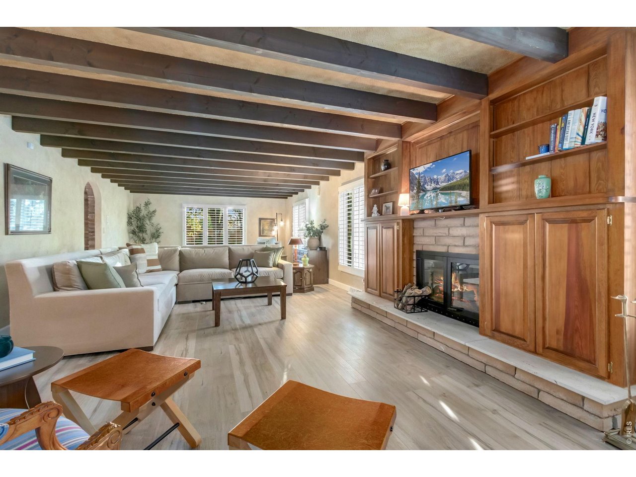 Property Photo 14 Spacious living room filled with natural light and stunning wood-beamed ceilings.