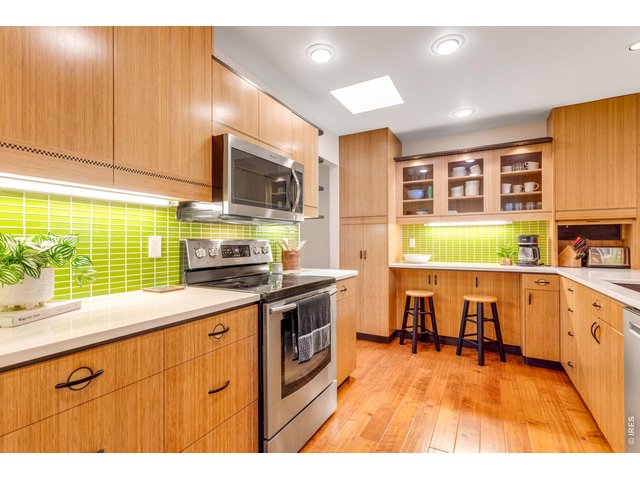 Property Photo 16 Artistic Modern & Impeccably updated throughout! Breakfast Bar in the kitchen, Shinnoki wood cabinetry, glass tile splash, Quartz countertops, all stainless appliances.