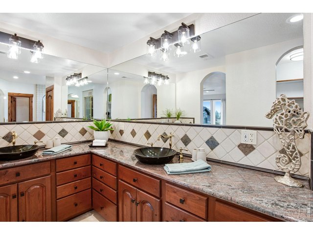 Property Photo 34 5-piece luxury bath with door to throne, 2 lifted vanities, granite slab countertops, full tile backsplash, full length corner mirrors, 2 new light fixtures, jetted soaking tub