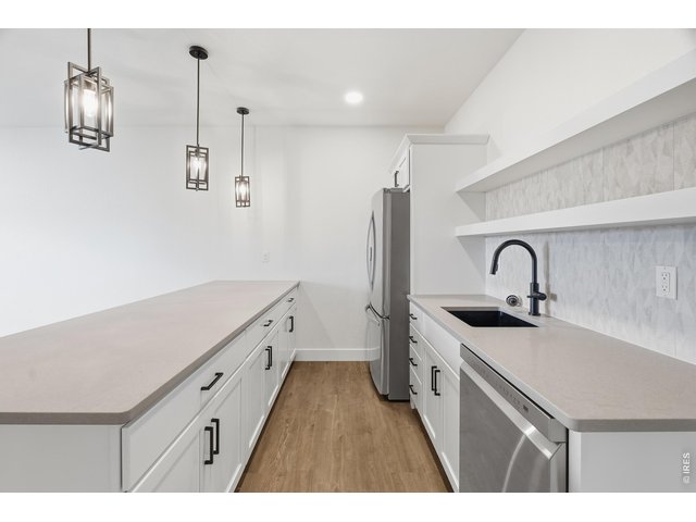 Property Photo 20 Stylish lower-level wet bar with generous counter space, open shelving, and full appliance package for effortless entertaining.