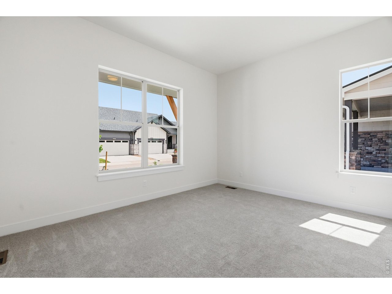 Property Photo 13 Bright and airy secondary main level bedroom with large windows and soft natural light.