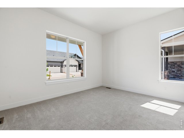 Property Photo 13 Bright and airy secondary main level bedroom with large windows and soft natural light.