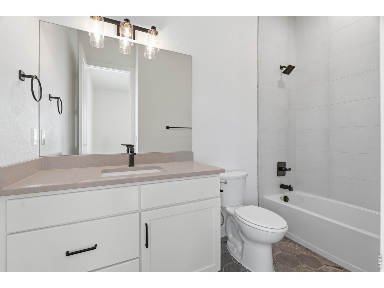 Property Photo 15 Stylish full bathroom featuring modern finishes, matte black fixtures, and full tub/shower surround.