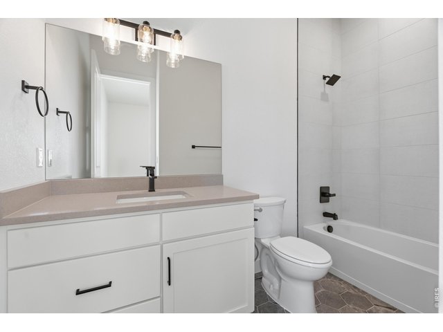 Property Photo 15 Stylish full bathroom featuring modern finishes, matte black fixtures, and full tub/shower surround.