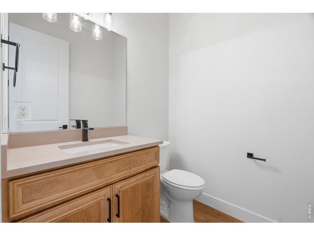 Property Photo 17 Convenient powder bath with designer finishes and warm wood cabinetry.
