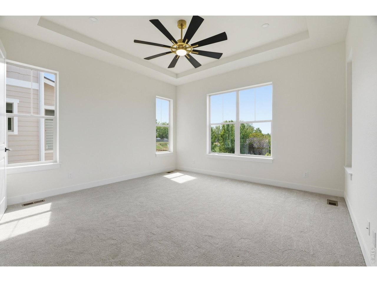 Property Photo 7 Expansive main level primary suite filled with natural light and peaceful backyard views.