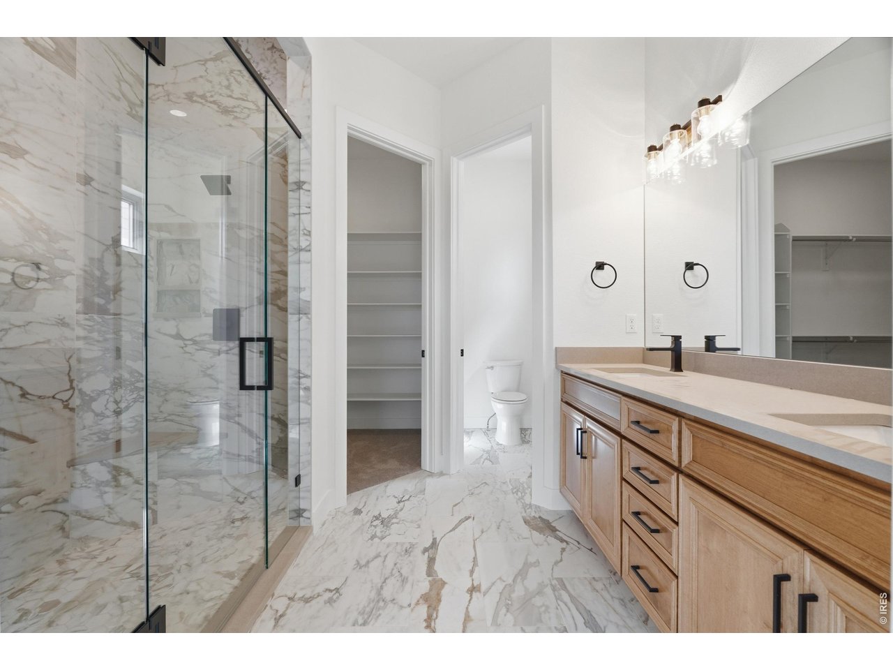 Property Photo 9 Luxurious primary bathroom with oversized dual vanity, statement tile work, and custom walk-in shower.
