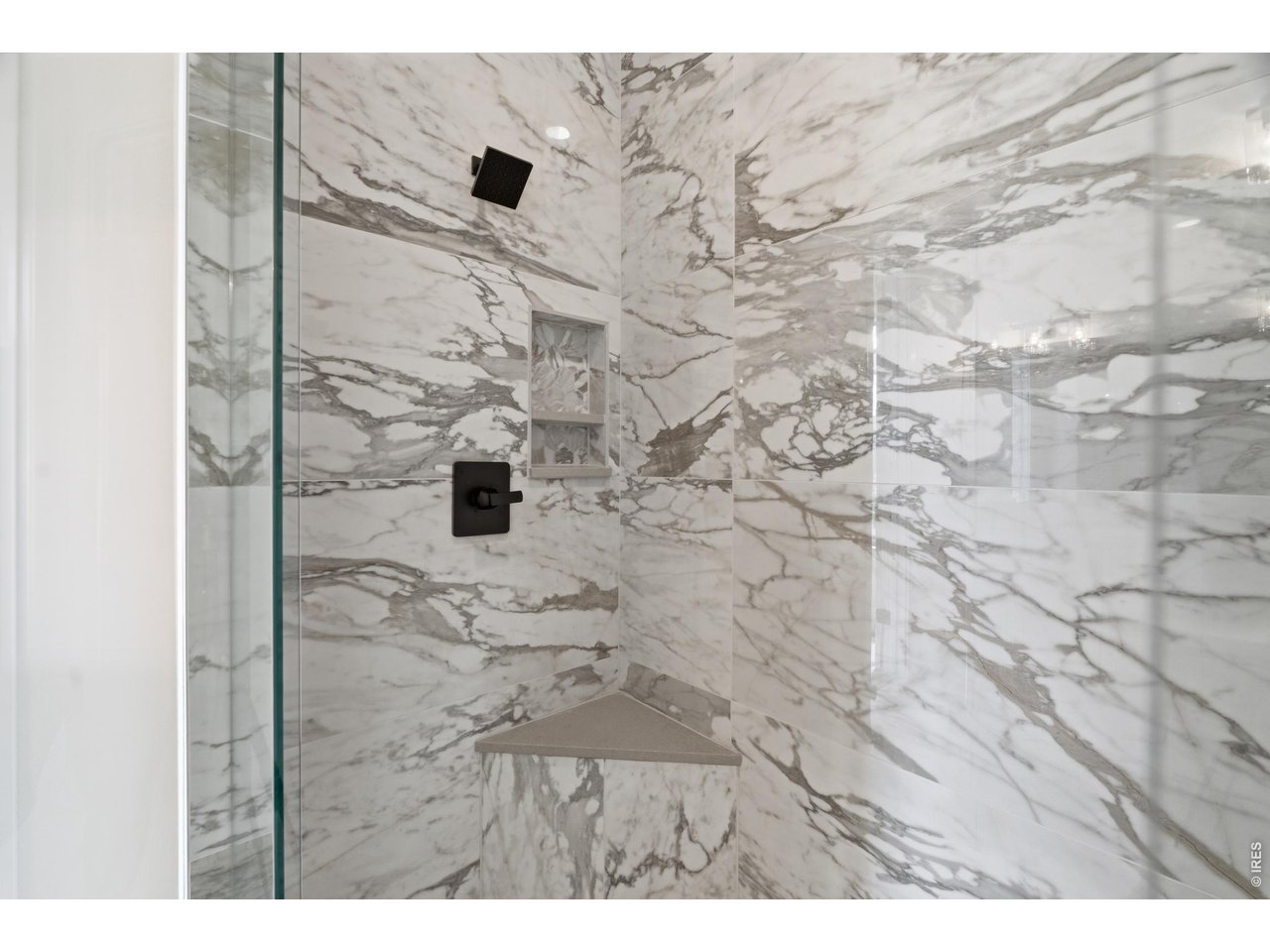 Property Photo 10 Stunning walk-in shower with dramatic full-height tile and built-in bench seating.