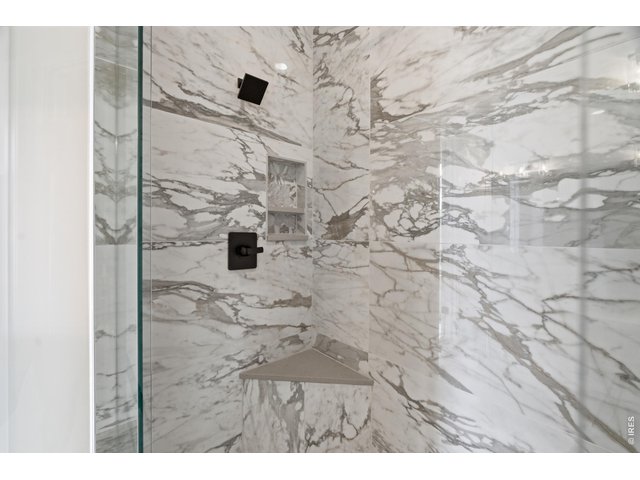 Property Photo 10 Stunning walk-in shower with dramatic full-height tile and built-in bench seating.