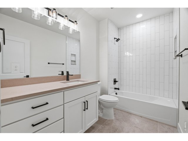 Property Photo 23 Full basement bathroom finished with timeless tile work, matte black fixtures, and clean modern design.