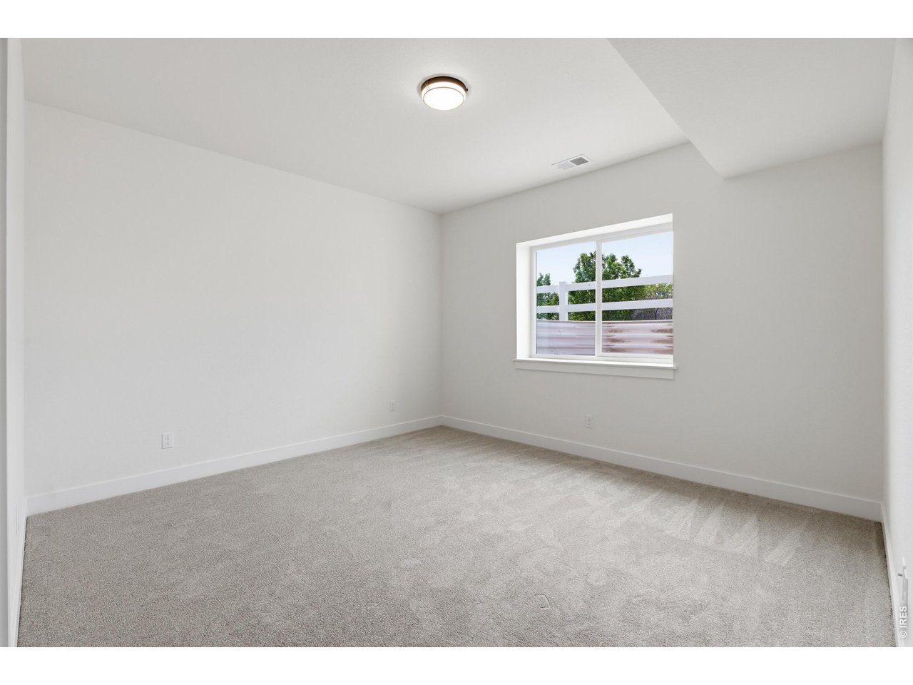 Property Photo 24 Oversized basement bedroom with natural light and flexible use potential for guests, hobbies, or a home gym.