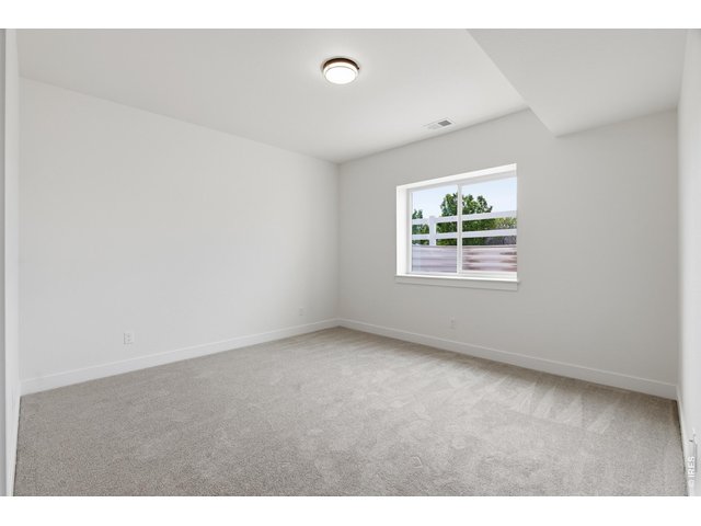 Property Photo 24 Oversized basement bedroom with natural light and flexible use potential for guests, hobbies, or a home gym.