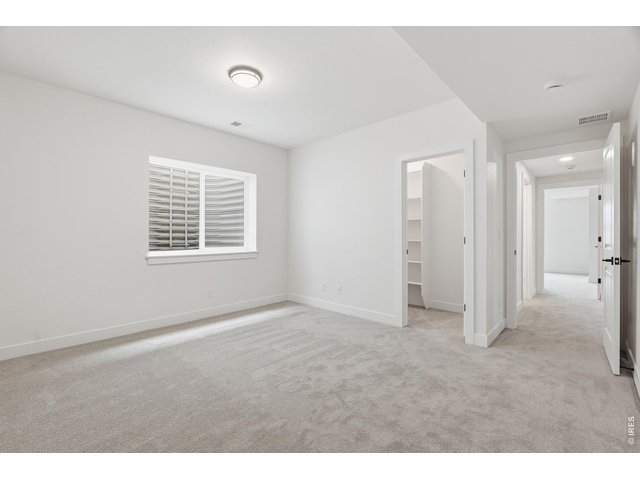 Property Photo 22 Generous lower-level bedroom with versatile layout and bright window detail.