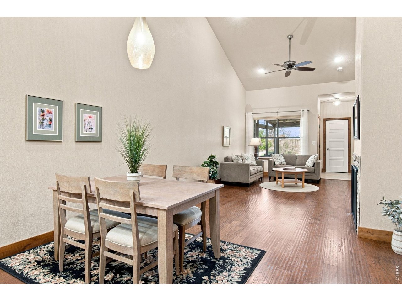 Property Photo 7 Light-filled dining area with soaring ceilings and hardwood flooring, conveniently situated between the kitchen and living room.