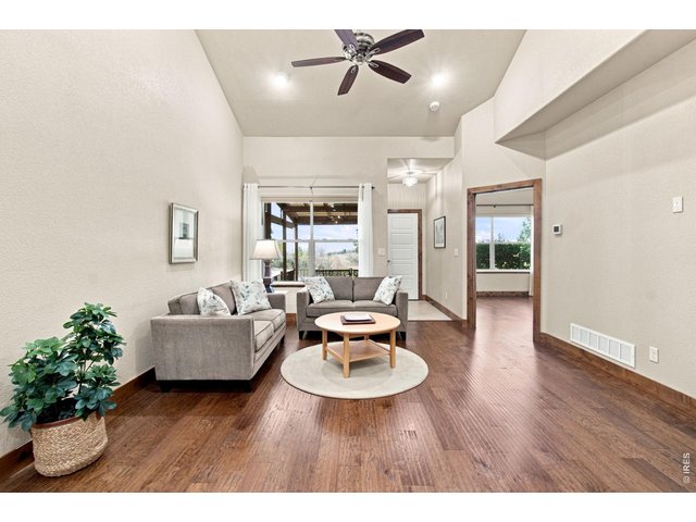 Property Photo 9 Inviting living room with vaulted ceilings, hardwood floors and large windows bringing in plenty of natural light.