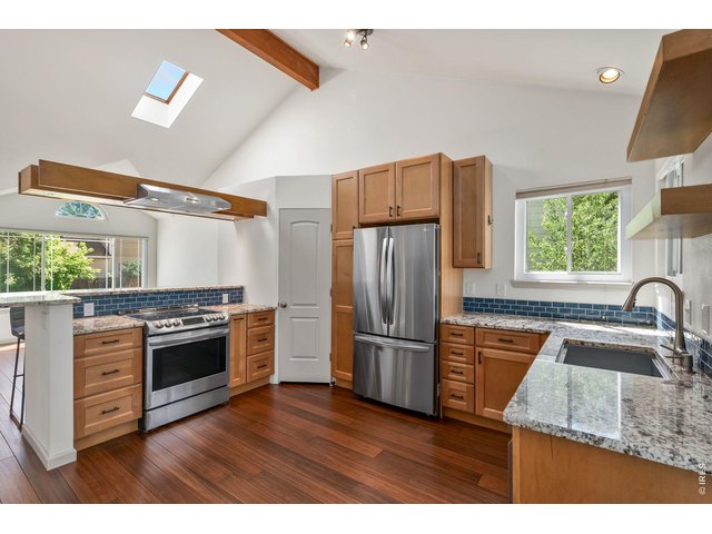 Property Photo 4 Amazing updated kitchen with stone countertops, stainless appliances, and floating range hood.