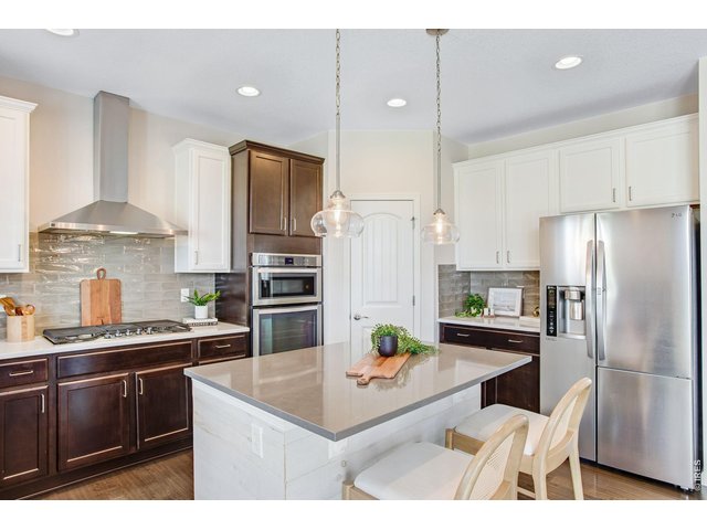 Property Photo 19 Kitchen features granite slab countertops, full glass backsplash, center island and breakfast bar, stainless steel appliances and a 5-burner gas range
