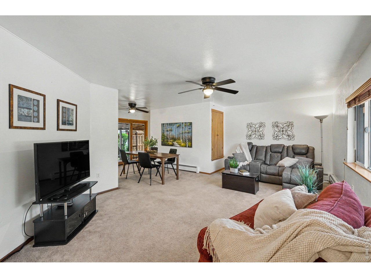 Property Photo 4 Bright and inviting living room with built-in storage and large picture window.